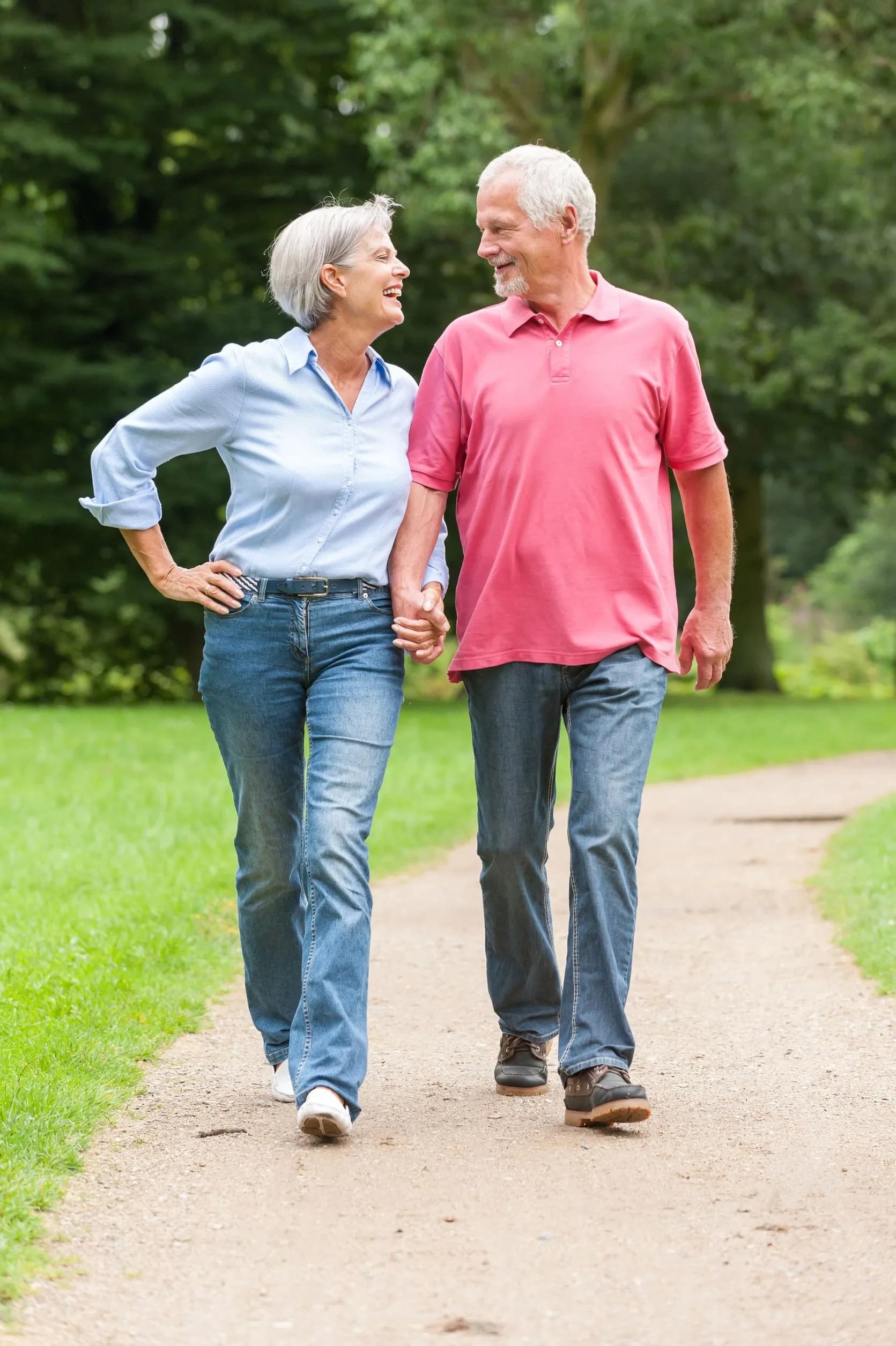 Active and happy senior couple walking in the park